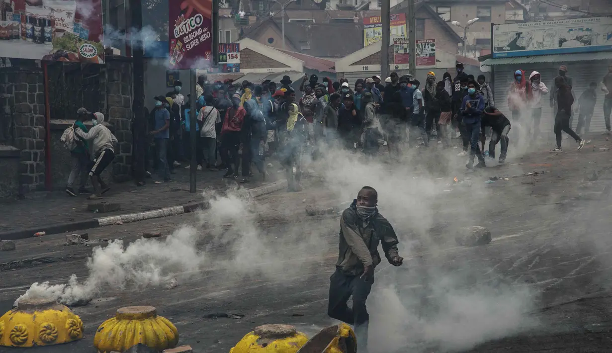 Seorang pengunjuk rasa melemparkan ke arah pasukan keamanan dalam demonstrasi menentang pemadaman air dan listrik yang berulang di Antananarivo pada 30 September 2025. (RIJASOLO/AFP)