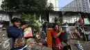 Warga membawa barang berharga saat alat berat merobohkan bangunan di kawasam Rawajati, Jakarta, Kamis (1/9). Penertiban tersebut menyebabkan warga terpaksa menyelamatkan barang berharga mereka ke tepi rel kereta api. (Liputan6.com/Immanuel Antonius)