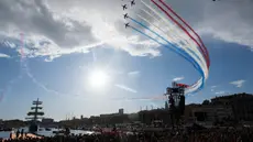 Tim terbang akrobatik elit Angkatan Udara Prancis "Patrouille de France" (PAF) terbang melewati kapal barque Belem bertiang tiga dari abad ke-19 Prancis di Vieux-Port (Pelabuhan Lama) di Marseille, pada tanggal 8 Mei 2024. (Nicolas TUCAT/AFP)