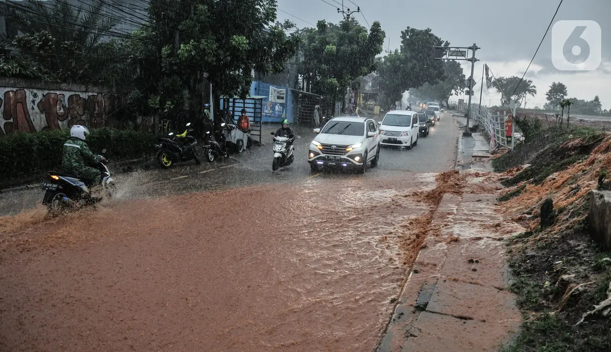 Kendaraan bergerak perlahan melintasi genangan lumpur di Jalan Raya Sawangan, Depok, Minggu (7/11/2021). Menurut warga setempat, banjir bercampur lumpur tersebut merupakan yang pertama kali yang diduga disebakan oleh proyek waduk perumahan yang belum rampung. (merdeka.com/Iqbal S Nugroho)