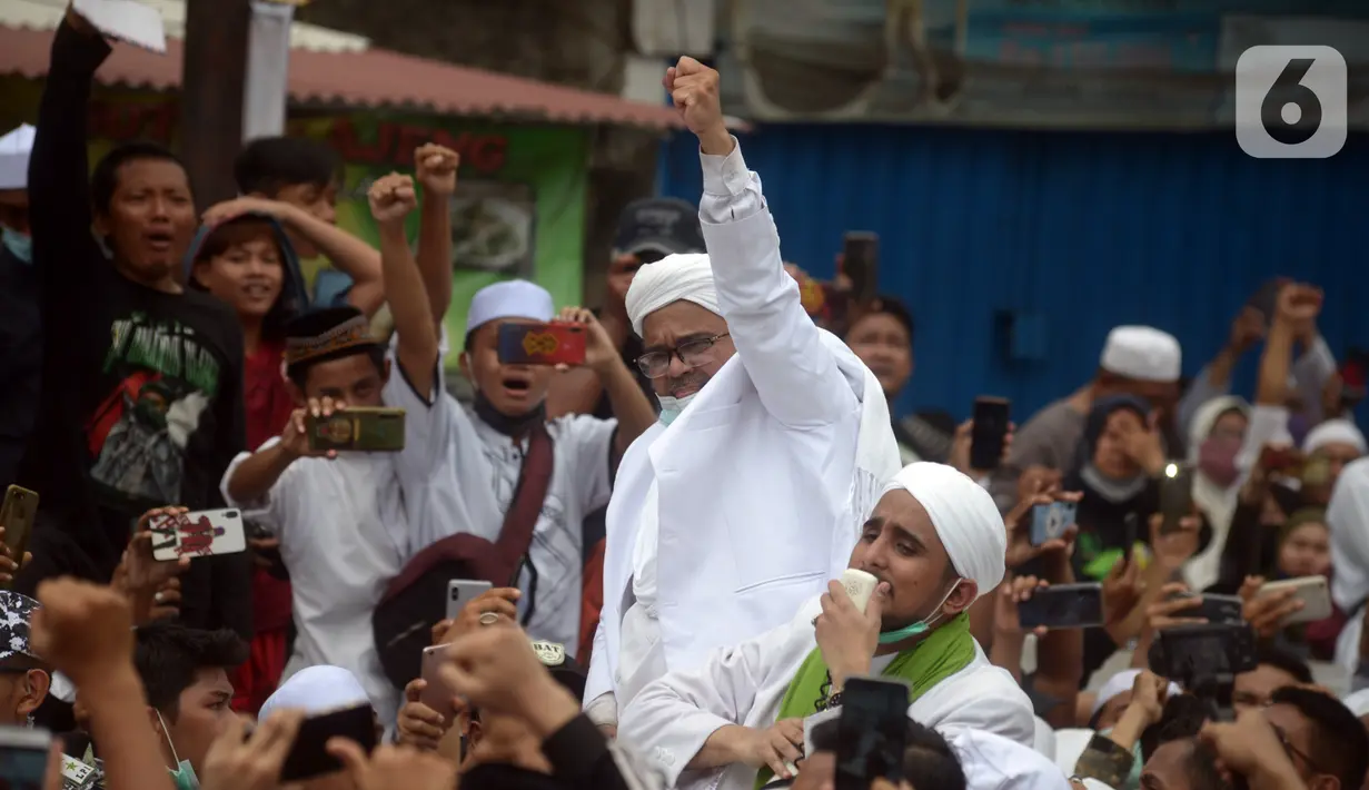 Rizieq Shihab menyapa massa pendukungnya saat tiba di kediamannya di Jalan Petamburan, Jakarta, Selasa (10/11/2020). Rizieq Shihab tiba di kediamannya usai pulang dari Arab Saudi. (merdeka.com/Imam Buhori)