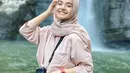 Nabila Ishma berusaha untuk terus tersenyum lebar seperti janjinya ke Eril. Nabila memiliki senyum yang sangat manis. Terlebih saat tersenyum ketika ia jalan-jalan destinasi wisata air terjun. Senyum manisnya ini banjir like dari netizen. (Liputan6.com/IG/@nabilaishma)