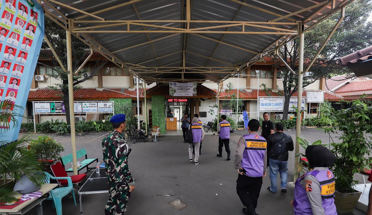Gerbang sekolah ditutup, dan akses masuk dibatasi oleh petugas gabungan. Tampak dalam foto, personel dari POM TNI AL dan tim dari psikologi kepolisian berada di area SMAN 72 Jakarta, Senin (10/11/2025). (merdeka.com/Arie Basuki)