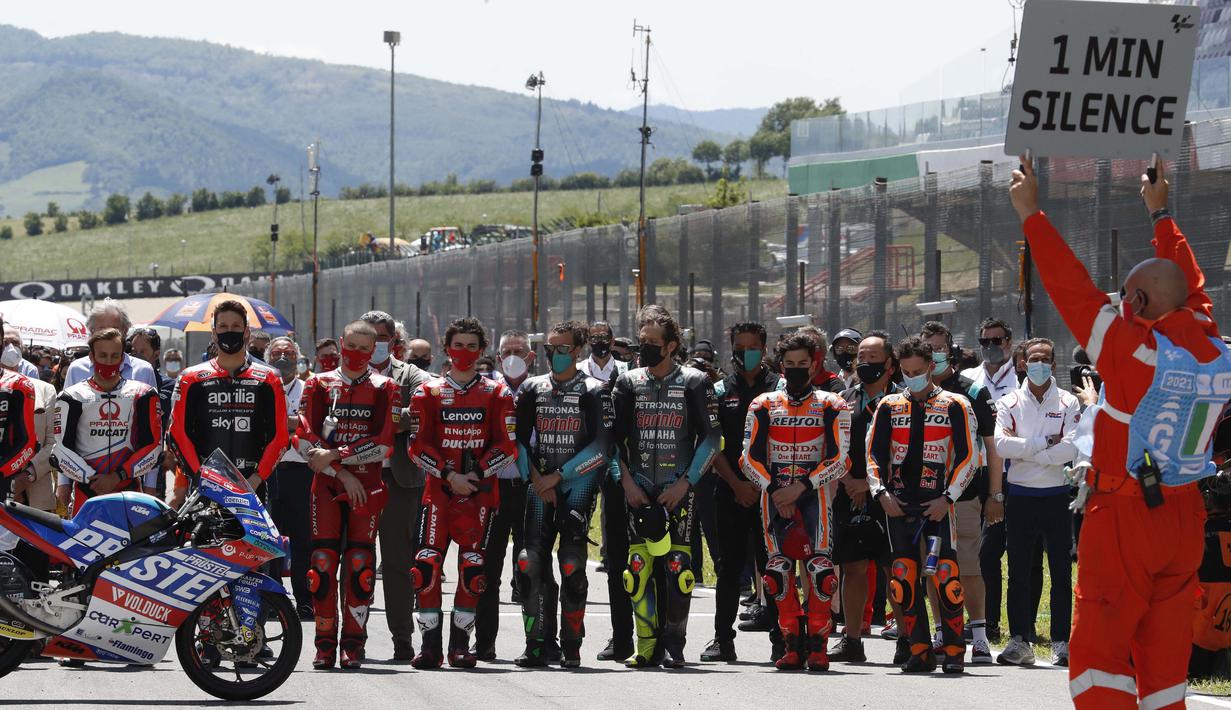 Pebalap MotoGP memberikan penghormatan terakhir dengan mengheningkan cipta selama satu menit bagi pebalap Moto3 Jason Dupasquier sebelum dimulainya balapan MotoGP Italia di Sirkuit Mugello. (Foto: AP Photo/Antonio Calanni)