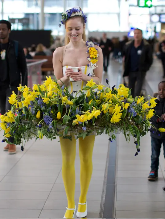 Model berpose dengan gaun yang dihiasi dengan bunga saat pameran bunga Keukenhof di Central Station di Utrecht, Belanda, (29/3). Pameran ini menghadirkan sekitar 20.000 bunga musim semi. (AP Photo / Peter Dejong)