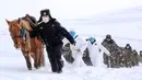 Petugas polisi mengenakan masker wajah saat melakukan perjalanan menantang saat akan mengunjungi rumah-rumah penduduk di daerah terpencil di Altay, Wilayah Xinjiang, China (19/2/2020). (AFP/STR)