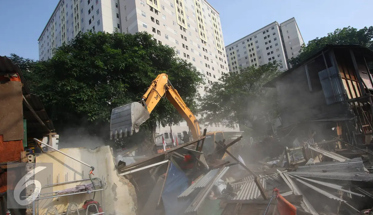 Alat berat merobohkan bangunan di kawasam Rawajati, Jakarta, Kamis (1/9). Penertiban puluhan bangunan liar di kawasan tersebut menyebabkan warga terpaksa menyelamatkan barang berharga mereka ke tepi rel kereta api. (Liputan6.com/Immanuel Antonius)