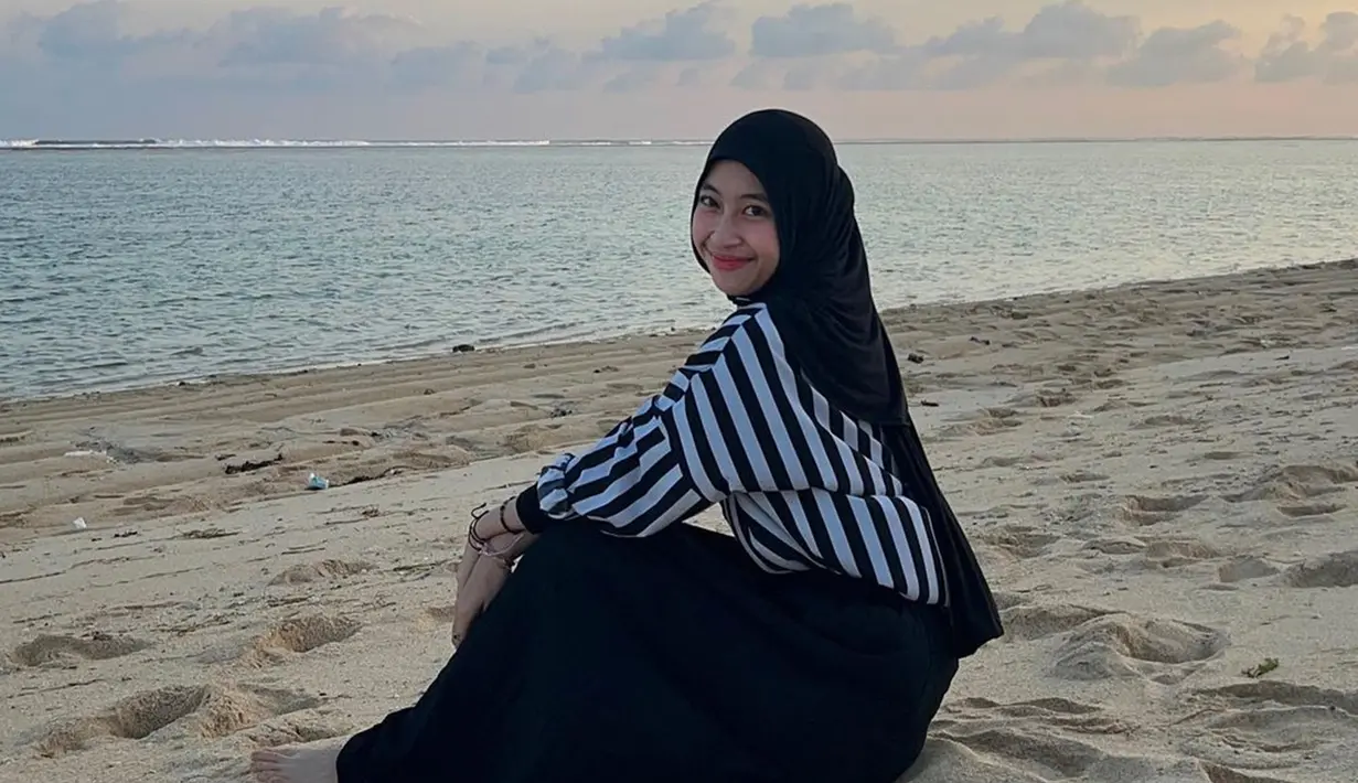 Adik dari Abidzar ini beberapa waktu lalu unggah foto di pantai. Ia tampak menikmati suaana pantai yang menuju ke waktu sunset. Momen Adiba duduk di pasir ini sungguh bikin adem lihatnya. (Liputan6.com/IG/adiba.knza)