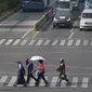 Warga beraktivitas menggunakan payung saat suhu udara mencapai 35 derajat Celcius di Kawasan Jalan MH Thamrin, Jakarta, Selasa (22/10/2019). (Liputan6.com/Helmi Fithriansyah) Event