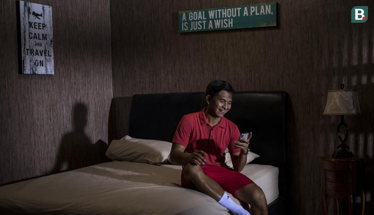 Petenis Indonesia, Christopher Rungkat, memainkan handphone saat berada di rumahnya di kawasan Bintaro, Jakarta, Kamis (19/7/2018). Dirinya merupakan salah satu petenis yang akan turun pada Asian Games XVIII. (Bola.com/Vitalis Yogi Trisna)