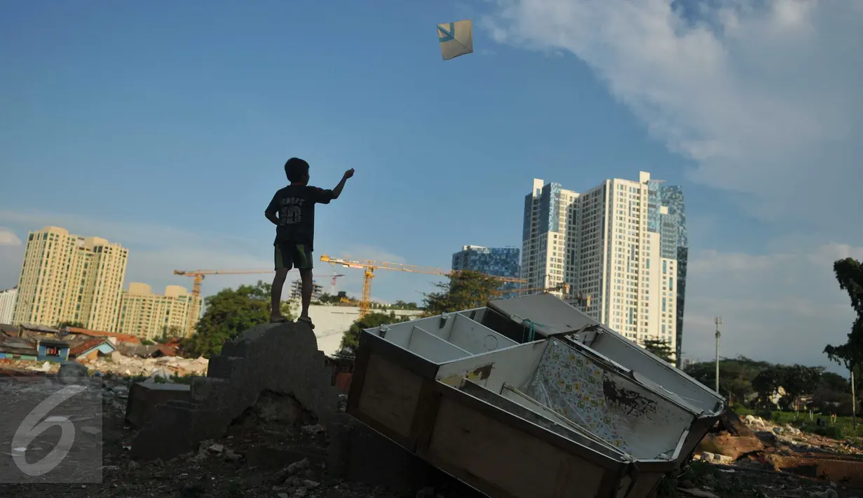 Seorang bocah bermain layang-layang di area Tempat Pemakaman Umum (TPU) Menteng Atas, Jakarta, Rabu (8/6). Minimnya tempat bermain membuat anak-anak bermain di Tempat Pemakaman Umum (TPU)  . (Liputan6.com/Gempur M Surya)