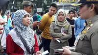 Petugas Satpol PP meminta warga tak memakai kaus 2019 Ganti Presiden di kegiatan CFD (Liputan6.com/ Putu Merta Surya Putra)