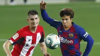 Pemain Barcelona, Riqui Puig, berebut bola dengan pemain Athletic Bilbao, Oihan Sancet, pada laga La Liga di Stadion Camp Nou, Selasa (23/6/2020). Barcelona menang 1-0 atas Athletic Bilbao. (AP/Joan Monfort)