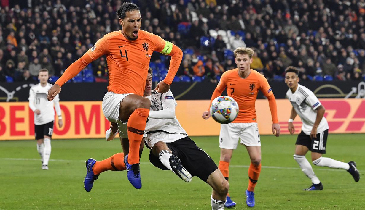 Bek Belanda, Virgil Van Dijk, berebut bola dengan penyerang Jerman, Thomas Mueller, pada laga UEFA Nations League di Veltins Arena, Gelsenkirchen, Senin (19/11/2018). Kedua tim bermain imbang 2-2. (AP/Martin Meissner)