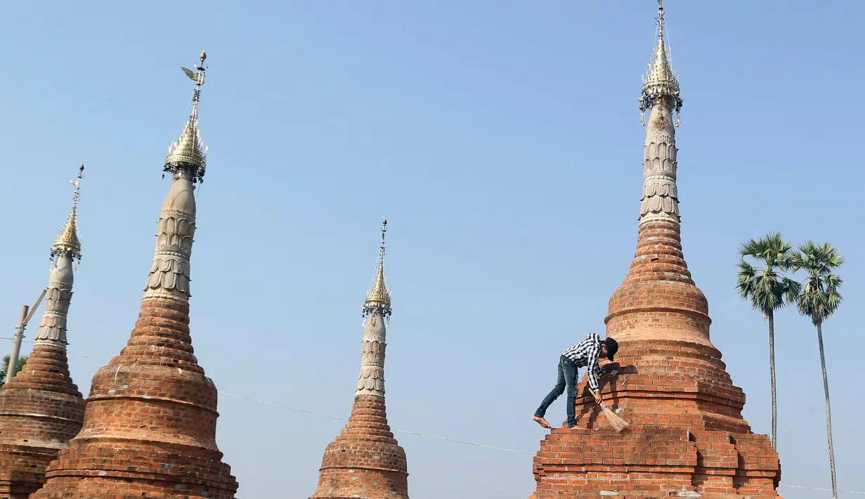 Relawan membersihkan pagoda Buddha kuno di Naypyitaw, Myanmar (27/1). Pagoda yang berada di ibu kota negara tersebut dibangun 160 tahun lalu pada masa dinasti Konbaung dan Amarapura. (AP Photo/Aung Shine Oo)