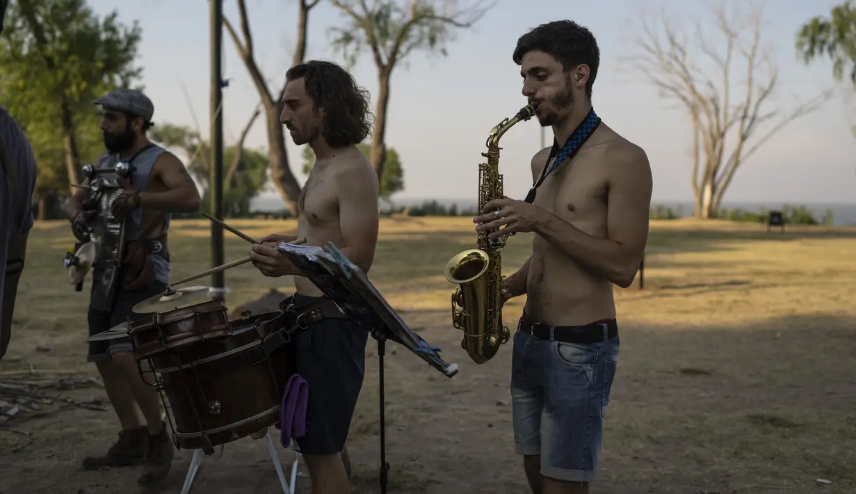 Musisi tampil di dekat sungai Rio de la Plata saat sore yang panas di Buenos Aires, Argentina, Kamis, 2 Maret 2023.  Menurut Badan Meteorologi Nasional, Buenos Aires tetap dalam status siaga merah untuk suhu ekstrem. (AP Photo/Rodrigo Abd)