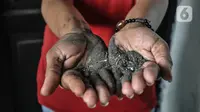 Warga menunjukkan debu batu bara yang mencemari Rusunawa Marunda, Jakarta Utara, Rabu (9/3/2022). Pencemaran debu batu bara mengakibatkan sejumlah penghuni mengalami sesak nafas, gatal-gatal. (merdeka.com/Iqbal S. Nugroho)