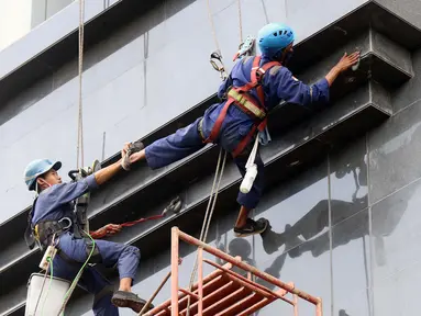 Aktivitas pekerja ketinggian di salah satu bagian gedung Pengadilan Negeri Jakarta Pusat, Rabu (18/11/2020). Berdasarkan data BP Jamsostek, angka klaim kecelakaan kerja semester I 2020 meningkat 128% dari periode yang sama 2019, dari 85.109 kasus menjadi 108.573. (Liputan6.com/Helmi Fithriansyah)