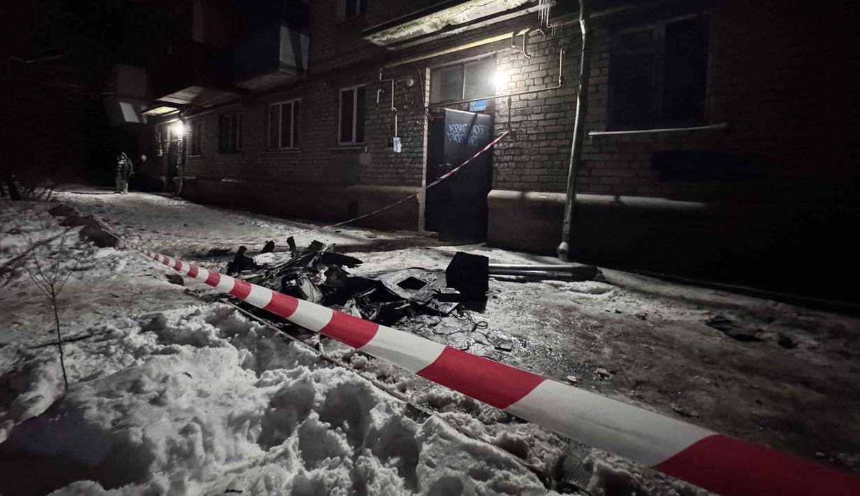 Namun dua warga sipil dilaporkan terluka akibat rentetan serangan drone dan artileri di 27 pemukiman wilayah Zaporizhzhia dalam 24 jam terakhir. Tampak sebuah foto yang menunjukkan puing-puing drone di dekat bangunan tempat tinggal yang rusak akibat serangan drone Rusia di Zaporizhzhia pada 2 Januari 2026, di tengah invasi Rusia ke Ukraina. (Darya NAZAROVA/AFP)