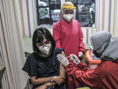 Vaksinator menyuntikkan vaksin Moderna saat vaksinasi dosis ketiga atau booster kepada tenaga kesehatan di Puskesmas Kecamatan Cilincing, Jakarta Utara, Senin (9/8/2021). Vaksinasi booster tersebut dimaksudkan untuk memberikan proteksi tambahan kepada tenaga kesehatan. (merdeka.com/Iqbal S. Nugroho)