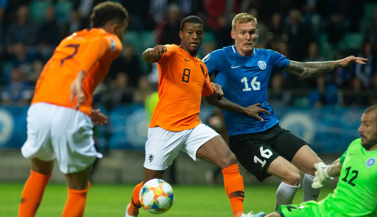 Gelandang Belanda, Georginio Wijnaldum, berusaha mengecoh kiper Estonia, Sergei Lepmetz, pada laga Kualifikasi Piala Eropa 2020 di Talinn, Estonia, Senin (9/9). Estonia kalah 0-4 dari Belanda. (AFP/Raigo Pajula)