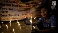 assa dari Solidaritas Merah Putih menggelar aksi lilin dan tabur bunga di lokasi bom Terminal Kampung Melayu, Jakarta, Kamis (25/5). Aksi tersebut sebagai bentuk malam solidaritas duka untuk bom Kampung Melayu.(Liputan6.com/Faizal Fanani)