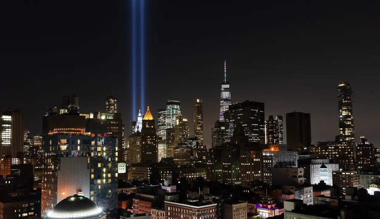 Instalasi cahaya bertajuk 'Tribute in Light' memperingati serangan gedung kembar menerangi langit di lower Manhattan, New York, Selasa (10/9/2019). Cahaya kembar itu jadi simbol menara kembar WTC yang hancur diserang kelompok pembajak pesawat 18 tahun silam. (AP/Mark Lennihan)