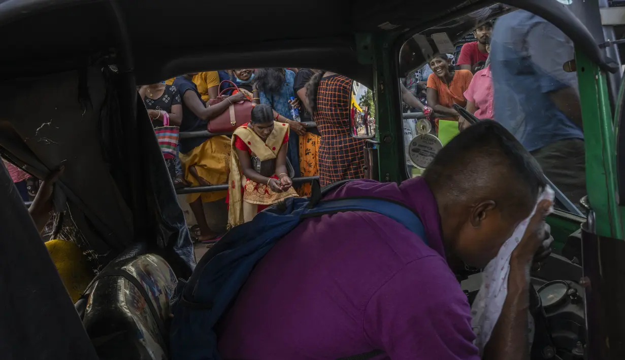 Seorang pria tidur di becak saat bersama dengan yang lain menunggu untuk mendapatkan paspor mereka di luar Departemen Imigrasi & Emigrasi di Kolombo, Sri Lanka, Senin (18/7/2022). Negara kepulauan Samudra Hindia itu dilanda krisis ekonomi yang belum pernah terjadi sebelumnya yang telah memicu ketidakpastian politik. (AP Photo/Rafiq Maqbool)