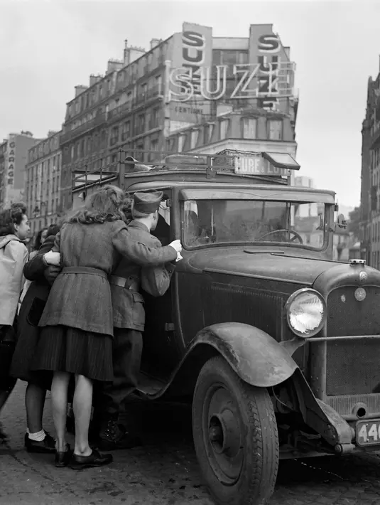Warga Paris menaiki van yang digunakan sebagai transportasi umum untuk pergi ke departemen Eure-et-Loir, pada Oktober 1944 di Paris, beberapa bulan setelah Pembebasan Paris, selama Perang Dunia Kedua. (AFP Photo)