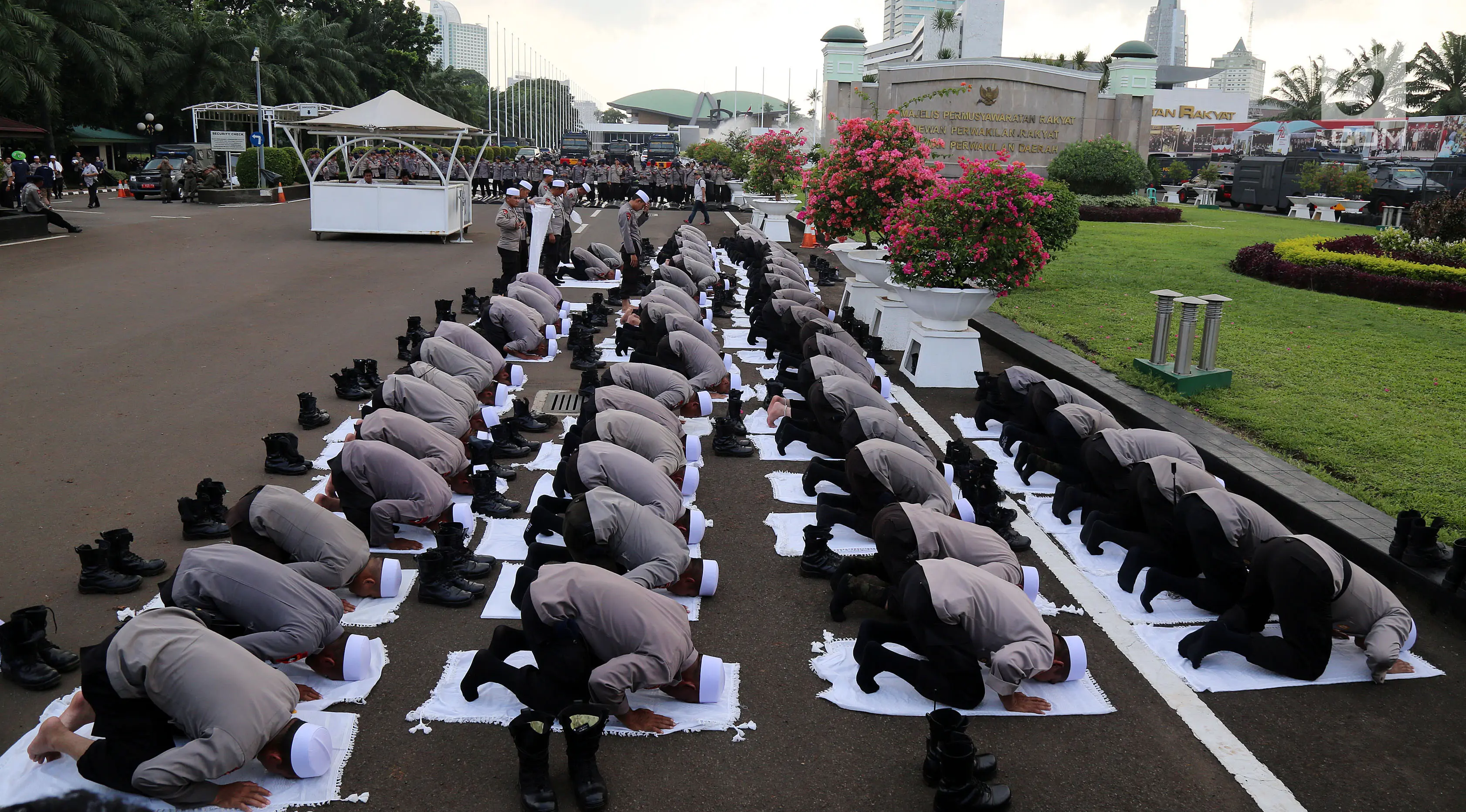 Pasukan Dzikir Asmaul Husna melakukan sujud saat salat di Gedung MPR/DPR, Senayan, Jakarta, Selasa (24/10). Sebanyak 299 personel dikerahkan untuk menjaga demo menolak Perppu Ormas di gedung DPR. (Liputan6.com/JohanTallo)