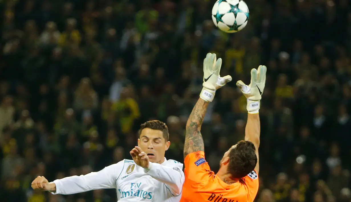 Kiper Borussia Dortmund, Roman Buerki menangkap bola yang ditendang pemain Real Madrid, Cristiano Ronaldo dalam lanjutan Liga Champions di Signal Iduna Park, Rabu (27/9). Dua gol Ronaldo mewarnai kemenangan Real Madrid 3-1. (AP/Michael Probst)