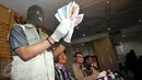 Petugas menunjukkan uang hasil Operasi Tangkap Tangan (OTT) milik anggota DPR RI dari Partai Hanura, Dewie Yasin Limpo di Gedung KPK, Jakarta, Rabu (21/10/2015). (Liputan6.com/Helmi Afandi)