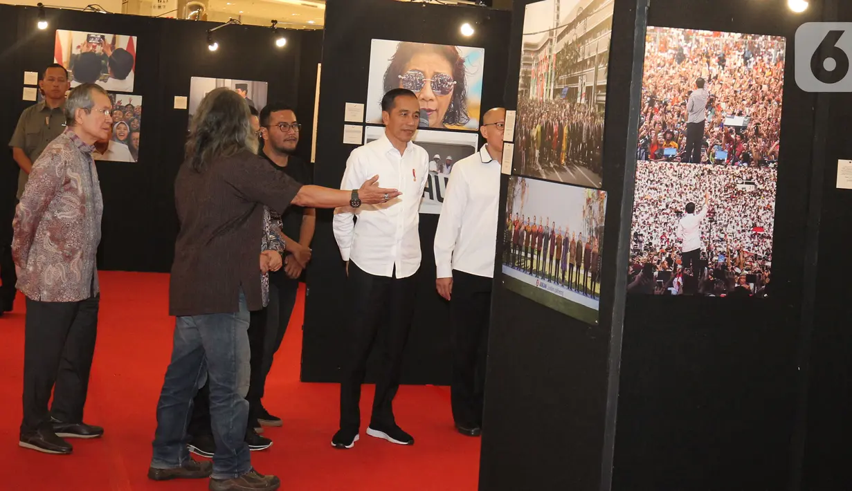 Presiden Joko Widodo atau Jokowi melihat pameran foto 'Membangun Indonesia'  di Jakarta, Selasa (12/11/2019). Pameran foto Membangun Indonesia itu menampilkan sejumlah capaian kinerja pemerintahan Presiden Joko-Widodo dan Wakil Presiden Jusuf Kalla. (Liputan6.com/Angga Yuniar)