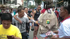 Petugas bersama ondel-ondel membagikan brosur sosialisasi E-Tilang saat car free day di bunderan HI, Jakarta, Minggu (28/10). Kegiatan sosialisasi E-Tilang tersebut agar masyarakat lebih mengetahui sanksi yang akan diberikan. (Liputan6.com/Faizal Fanani)