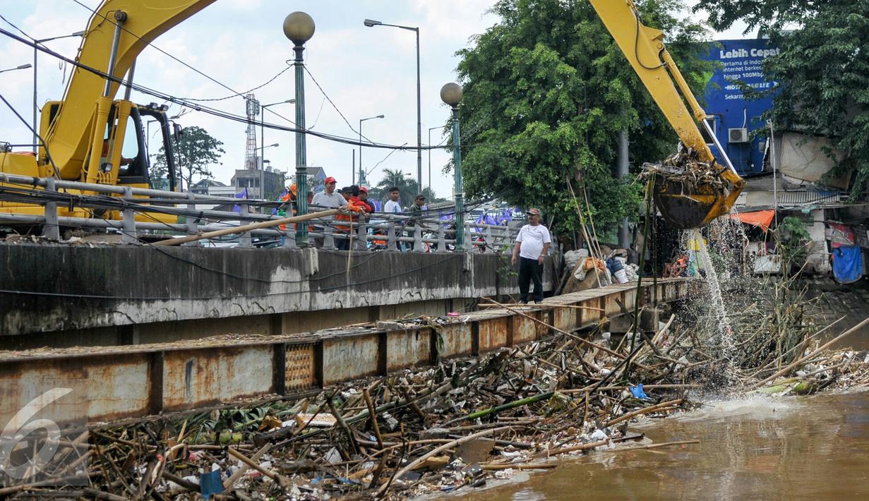 Petugas Sudin Kebersihan DKI Jakarta menurunkan alat berat untuk mengangkut sampah yang menumpuk di jembatan Kampung Melayu, Jatinegara, Jakarta Timur, Minggu (3/4/2016). (Liputan6.com/Yoppy Renato)