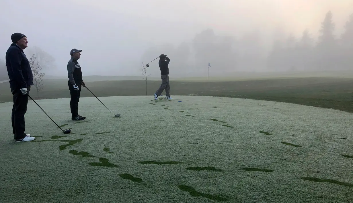 Seorang pegolf memukul bola saat bermain dalam kabut tebal di Lapangan Golf Russley di Christchurch, Selandia Baru, Sabtu (25/5/2019). Beberapa penerbangan di Bandara Christchurch ditunda atau dibatalkan karena kabut tebal menyelimuti kota tersebut. (AP Photo/Mark Baker)