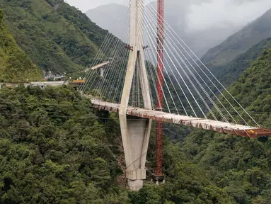 Penampakan sebuah jembatan gantung sebelum dihancurkan oleh para insinyur di Chirajara, Kolombia, Rabu (11/7). Sebelumnya, sebagian jembatan runtuh dan menewaskan sembilan pekerja saat pembangunannya pada Januari lalu. (AP Photo/Fernando Vergara)