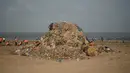 Petugas kebersihan berada di samping tumpukan sampah plastik terlihat di pantai Juhu di Mumbai, India (2/6). (AFP PHoto/Punit Paranjpe)