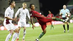 Pemain Portugal, Nani (kanan) berusaha menahan bola saat dihadang para pemain Latvia pada laga Kualifikasi Piala Dunia 2018 di Algarve stadium, Faro (13/11/2016). Portugal menang 4-1. (AFP/Francisco Leong)