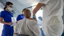 Pengungsi Afghanistan divaksin COVID-19 di kamp pengungsian Palang Merah Italia, Avezzano, Italia, Selasa (31/8/2021). Kamp karantina ini diduga akan tutup dalam seminggu ke depan karena karantina berakhir dan mereka dipindahkan ke struktur lain untuk mengajukan suaka. (AP Photo/Andrew Medichini)