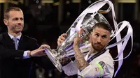 Presiden UEFA, Aleksander Ceferin memberikan piala kepada kapten Real Madrid, Sergio Ramos usai Real Madrid memenangkan pertandingan Liga Champions di Stadion Cardiff, Wales (3/6). (AFP Photo/Javier Soriano)