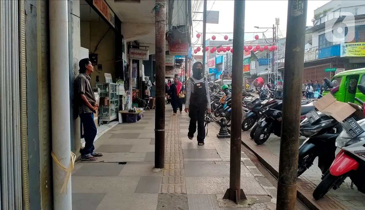 Sejumlah tiang berdiri di jalur pedestrian sepanjang Jalan Surya Kencana, Kota Bogor, Jawa Barat, Sabtu (3/12/2022). Jalur pedestrian yang seharusnya menjadi akses pejalan kaki dan ramah bagi kaum disabilitas itu tidak berfungsi dengan semestinya. (Liputan6.com/Magang/Aida Nuralifa)