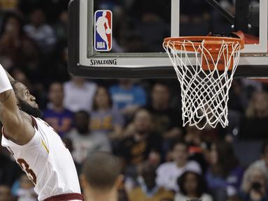 Pebasket Cleveland Cavaliers, LeBron James, memasukkan bola saat pertandingan melawan Charlotte Hornets pada laga NBA di Spectrum Center, Rabu (28/3/2018). Cleveland Cavaliers menang 118-105 atas Charlotte Hornets. (AP/Chuck Burton)