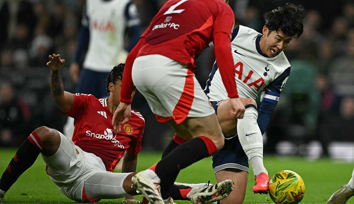 Pemain Tottenham Hotspur, Son Heung-min (kanan) berusaha melepaskan diri dari penjagaan pemain Manchester United pada laga perempat final Carabao Cup 2024/2025 di Tottenham Hotspur Stadium, London, Jumat (20/12/2024). (AFP/Ben Stansall)