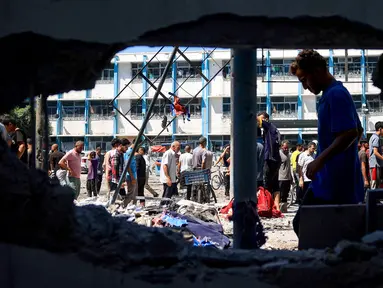 Warga Palestina memeriksa kerusakan di Sekolah Al-Razi yang dikelola organisasi Persatuan Bangsa Bangsa (PBB) di kamp pengungsi Nuseirat setelah serangan Israel pada 16 Juli 2024. (Eyad BABA/AFP)