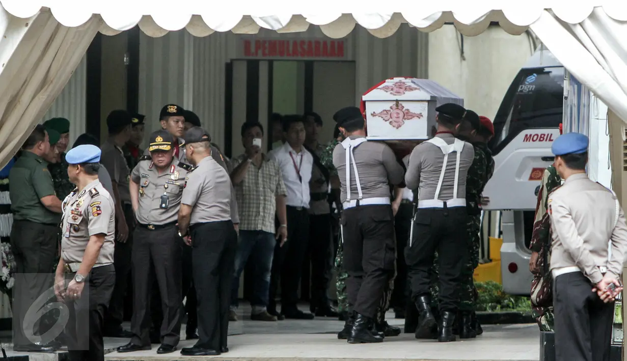 Petugas TNI dan Polisi membawa peti jenazah korban dari jatuhnya helikopter TNI di Poso, Jakarta, Senin (21/3/2016). Jenazah korban akan menjalani proses identifikasi di RS Polri (Liputan6.com/Yoppy Renato)