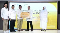 Direktur Sales & Distribution BSI Anton Sukarna menyerahkan Kartu Debit Haji Indonesia kepada calon jemaah Haji Indonesia dari KBIH Al-Hasanah didampingi Direktur Pengelolaan Dana Haji dan Sistem Informasi Haji Terpadu (Dirjen PHU) Kemenag Jaja Jaelani (kedua kiri) dan SVP Islamic Ecosystem BSI M. Syukron Habiby (kiri) pada acara Manasik Akbar di The Tower, Jakarta (20/05/2023) (Liputan6.com)