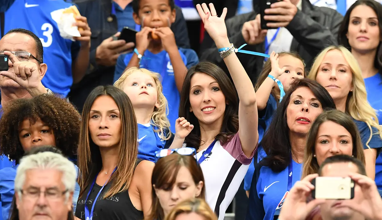 Istri Olivier Giroud, Jennifer Giroud (tengah) saat menyaksikan pertandingan antara Prancis melawan Rumania pada kualifikasi Grup A Piala Eropa 2016 di stadion Stade de France, di Saint-Denis, Paris, Prancis, (10/6). (AFP PHOTO/FRANCK FIFE)