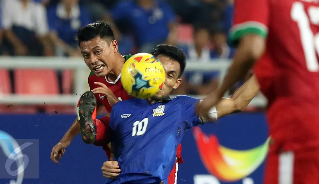 Bek Timnas Indonesia, Benny Wahyudi (kiri) berebut bola dengan Teerasil Dangda (Thailand) saat laga final kedua Piala AFF 2016 di Rajamangala National Stadium, Bangkok, Sabtu (17/12). Thailand menang 2-0 atas Indonesia. (Liputan6.com/Helmi Fithriansyah)