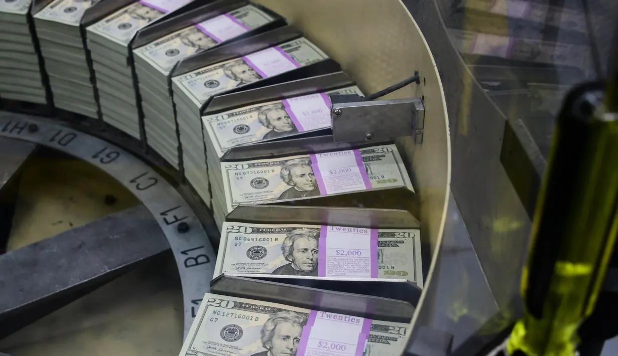 Paket uang kertas 20 USD yang baru dicetak diproses untuk bundling dan pengemasan di Biro Pengukiran dan Percetakan AS, Washington, Amerika Serikat, Jumat (20/7). (Eva HAMBACH/AFP)